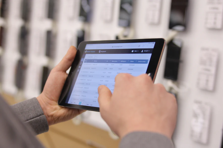 Depo rafları önünde tablet kullanan bir el